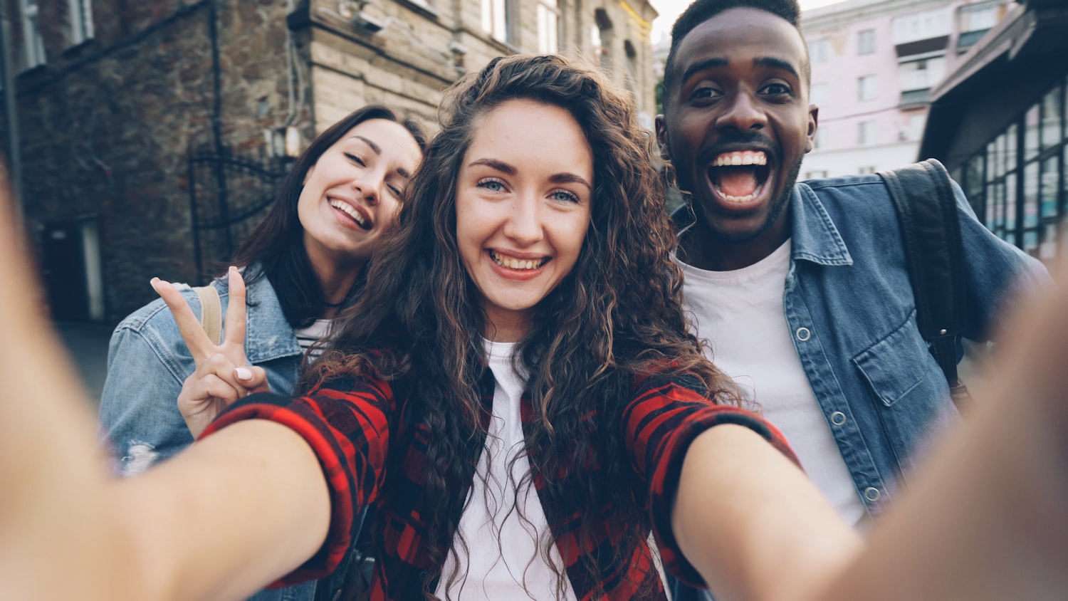 Trois amis qui font un selfie en voyage dans une ville.