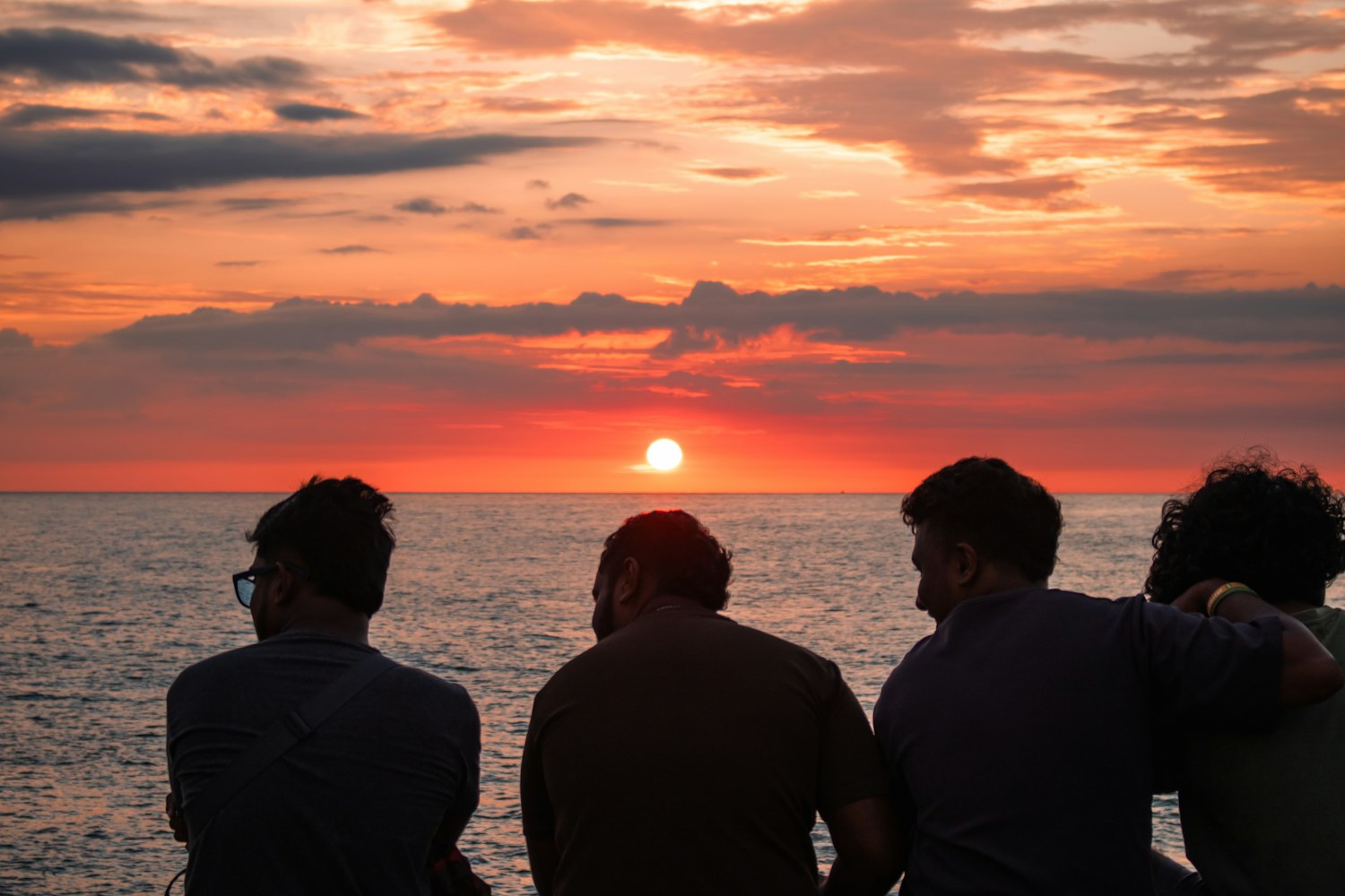 Des amis qui regardent le coucher de soleil ensemble.